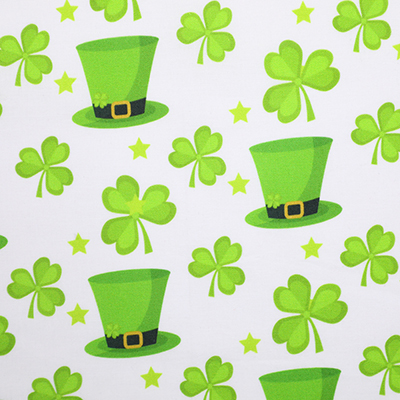 White fabric with green St. Patrick's Day-themed pattern, featuring shamrocks and leprechaun hats.