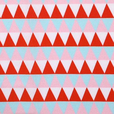 Fabric with a repeating pattern of red, pink, and light blue triangles arranged in horizontal rows.