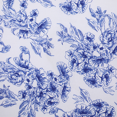 A close-up of a blue floral fabric with intricate and detailed flower patterns on a white background.